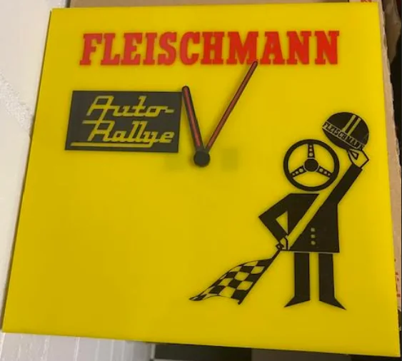 Gelbe quadratische Fleischmann-Wanduhr mit Auto-Rallye-Schild und Flaggenmännchen